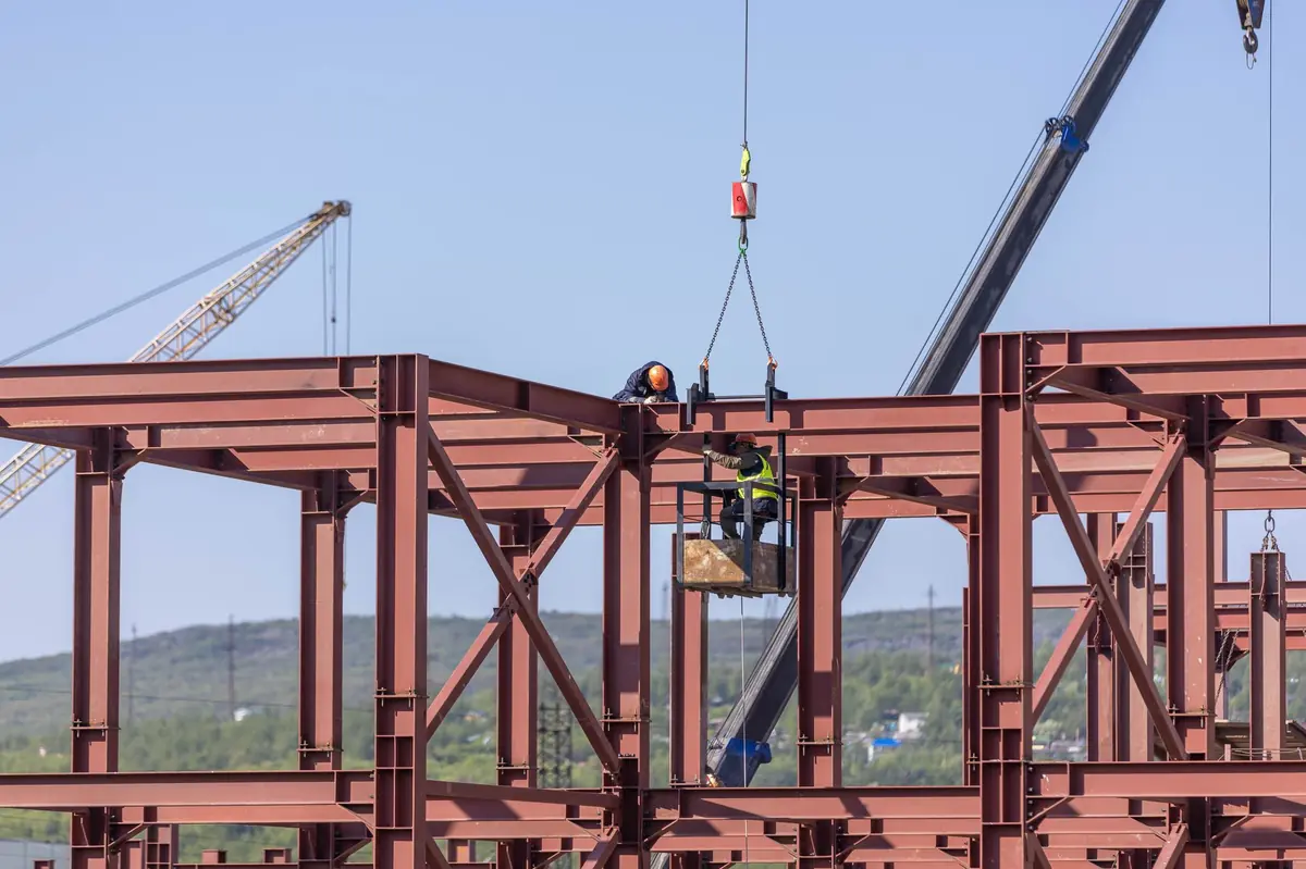Workers on a steel frame structure at a construction site