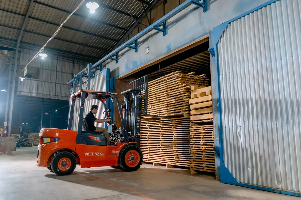 Forklift operator moving palletized materials in a warehouse